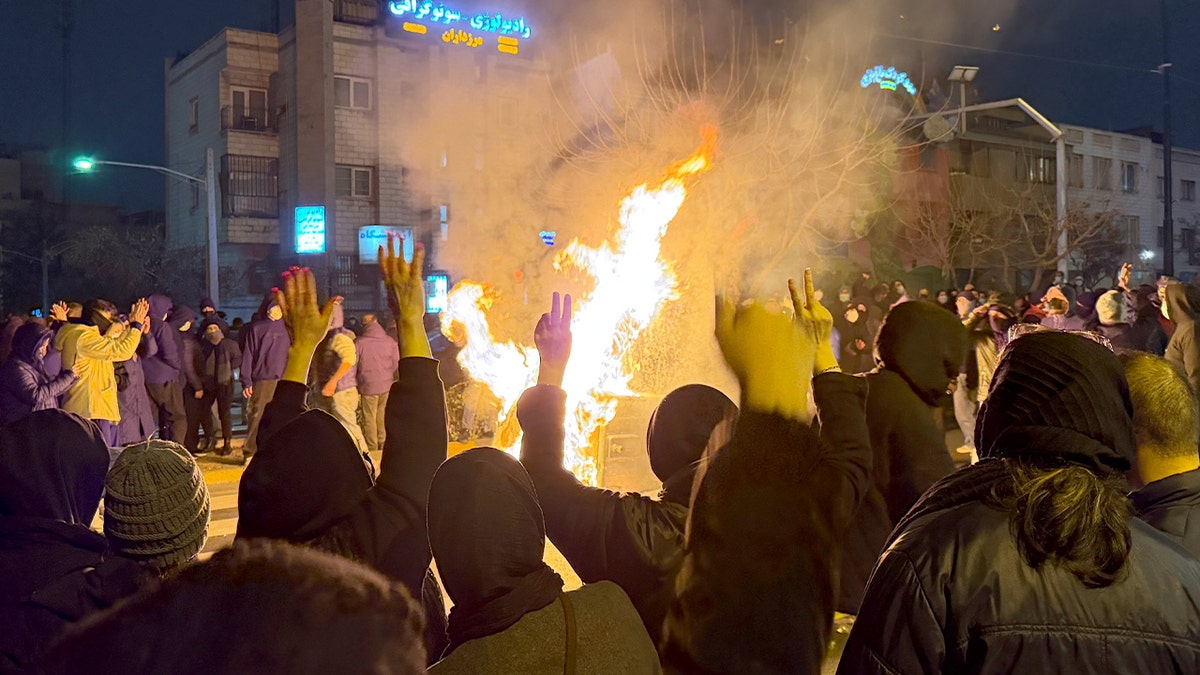 Crowd of demonstrators gathered in central Tehran holding signs and chanting slogans.