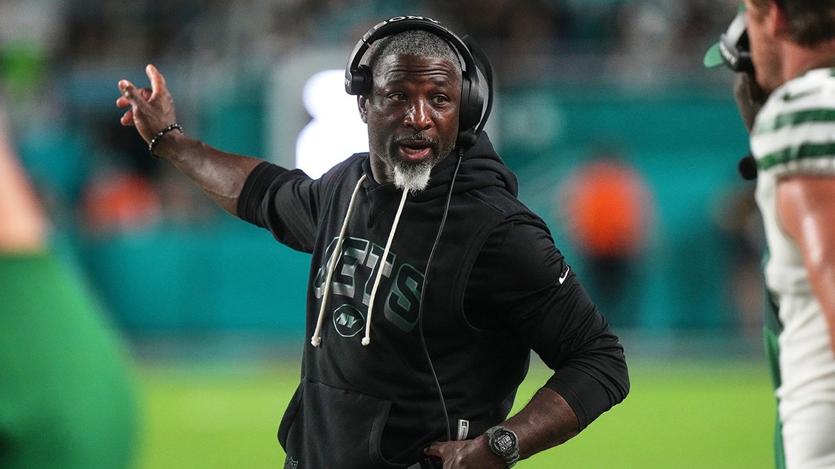 Aaron Glenn instructs staff on the sideline