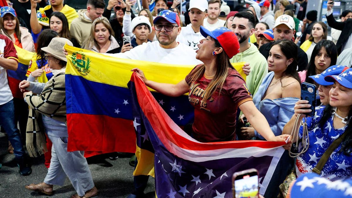 People in Miami hold Venezuelan and U.S. flags while reacting to news of President Nicolás Maduro’s capture.