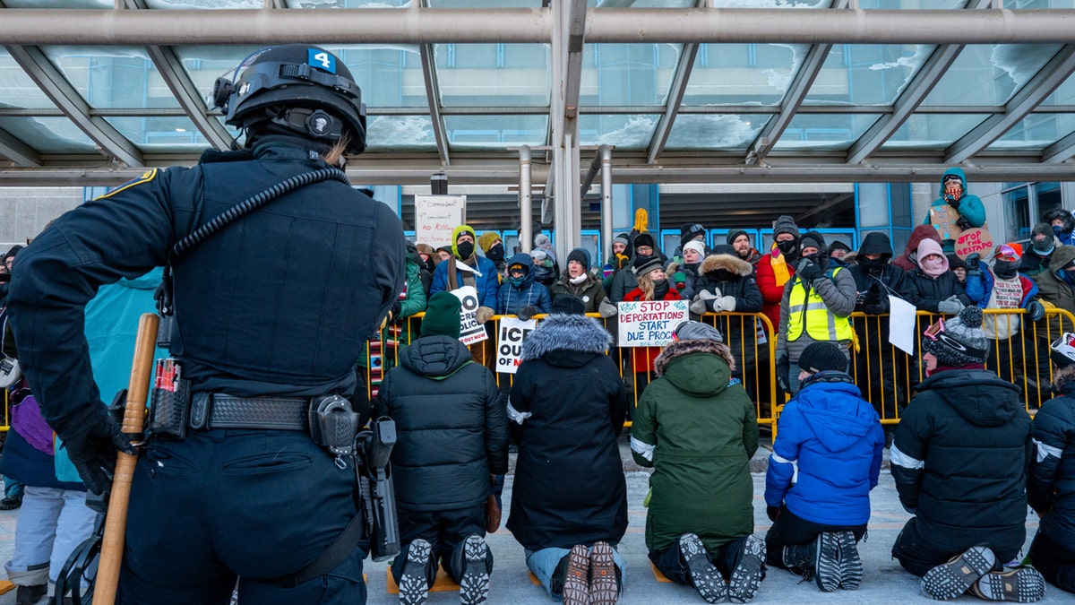 Protesters kneel in front of crowd
