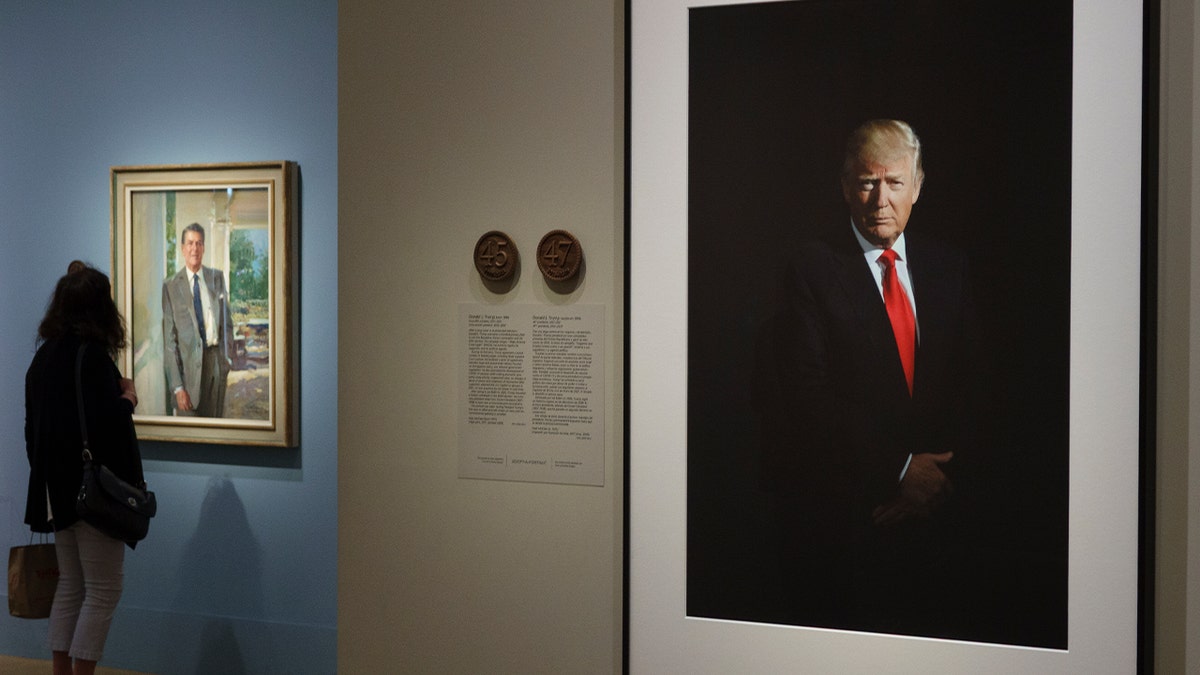 a portrait of trump in front of black background displayed on wall