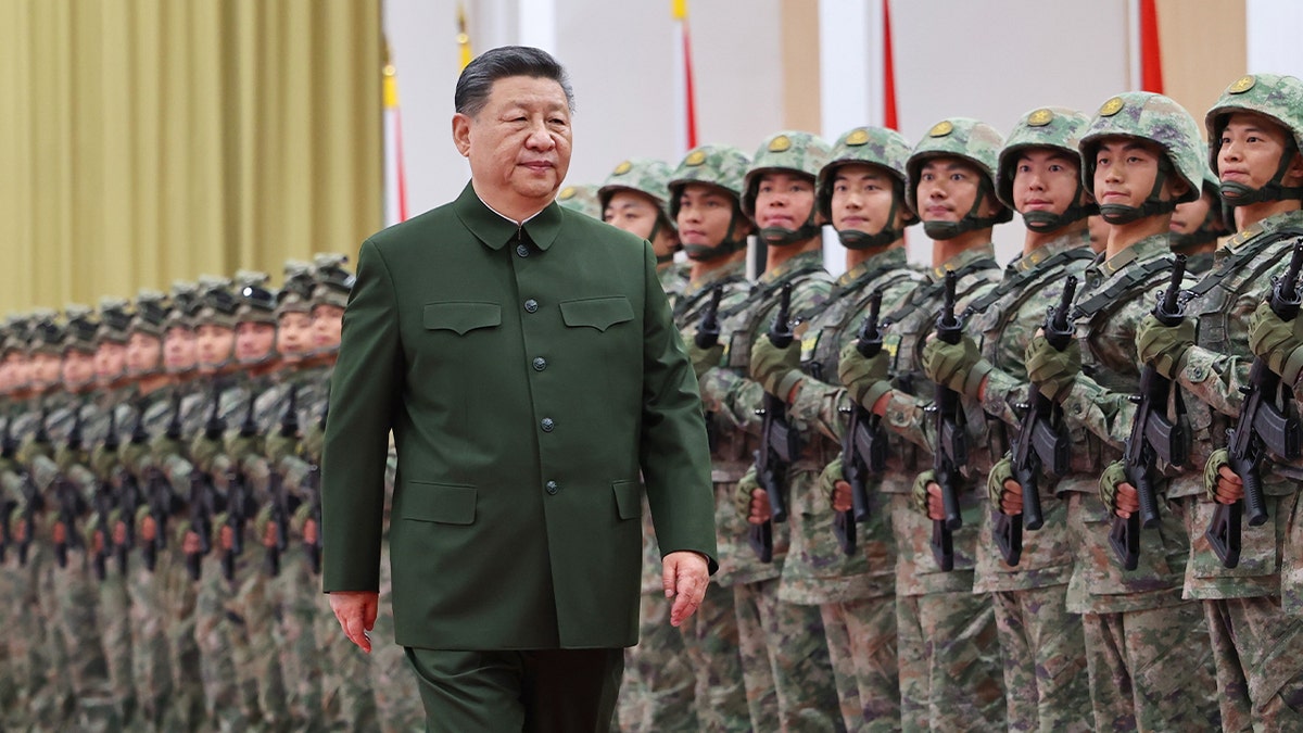 Chinese President Xi Jinping walking with army in background.