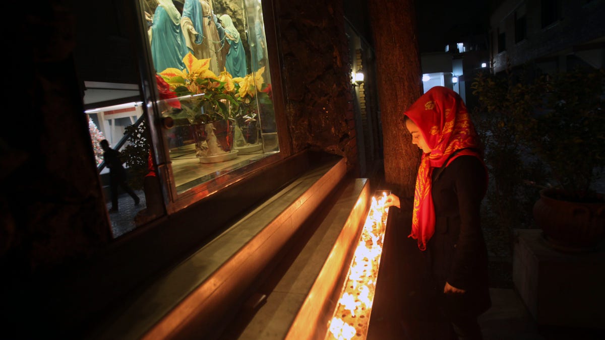 A female Iranian Christian lights candle at the Saint Mary Chaldean- Assyrian Catholic church, on the Christmas eve, in downtown Tehran, Iran, Monday, Dec. 24, 2012. Iran's constitution gives protected status to Christians, Jews and Zoroastrians, but many religious minorities sense growing pressures from the Islamic state. Iran has claimed as a point of pride that it makes space for other religions. It reserves parliament seats for Jewish and Christian lawmakers and permits churches, Roman Catholic, Armenian Orthodox and others, as well as synagogues and Zoroastrian temples that are under sporadic watch by authorities. Religious celebrations are allowed, but no political messages or overtones are tolerated. In past years, authorities have staged arrests on Christians and other religious minorities. (AP Photo/Vahid Salemi)