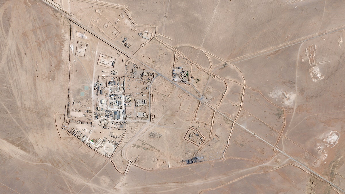 Satellite view of a remote military installation with buildings and infrastructure in a desert area of Syria.
