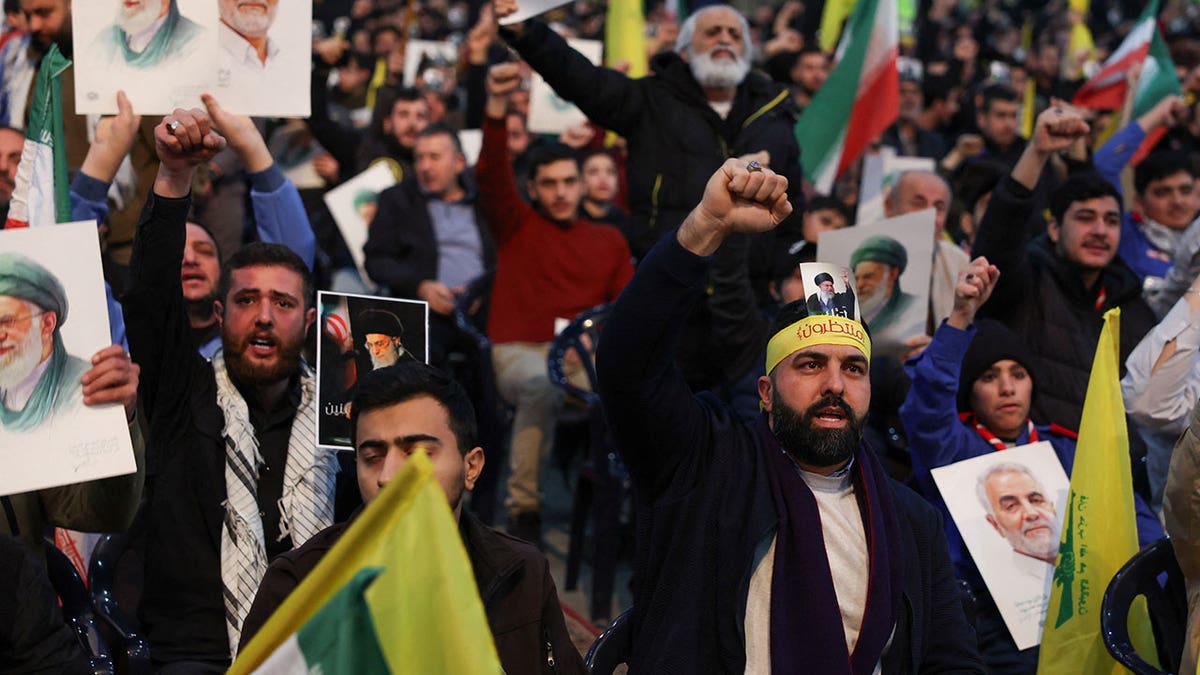 People gesture as Hezbollah leader Naim Qassem gives a televised address, during a rally in solidarity with Iran and Iran's Supreme Leader Ayatollah Ali Khamenei, at Beirut's southern suburbs, Lebanon