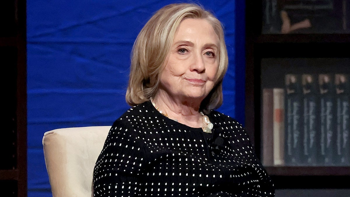 Hillary Rodham Clinton speaks onstage while standing at a podium during a book event.
