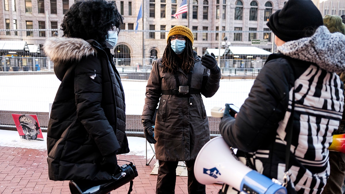 Marcia Howard wearing mask speaking with BLM activists in snow
