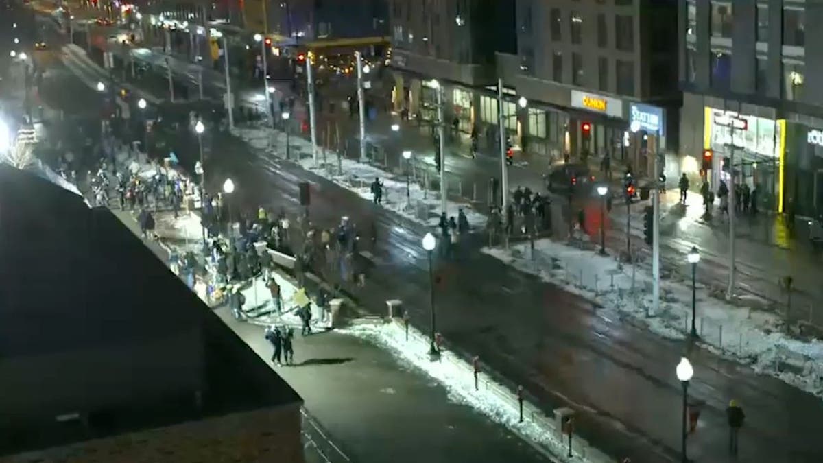 Aerial view of police and protesters outside a Minneapolis hotel during an anti-ICE demonstration.