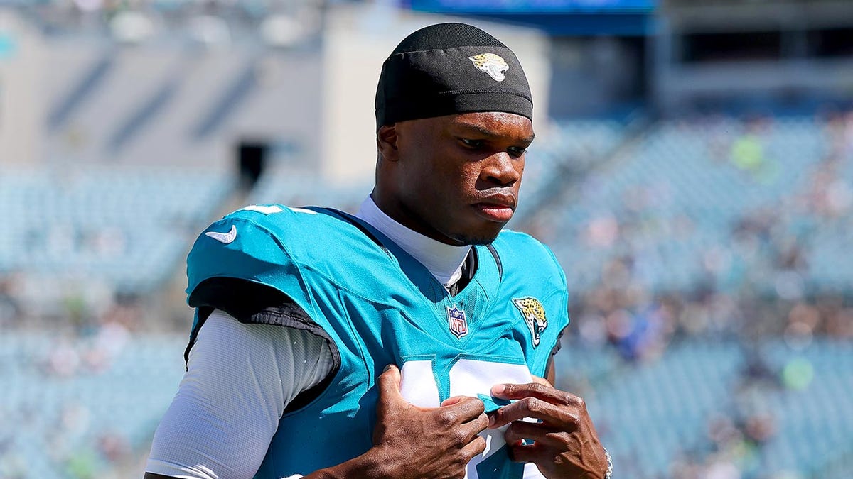 Travis Hunter walks with head down on field