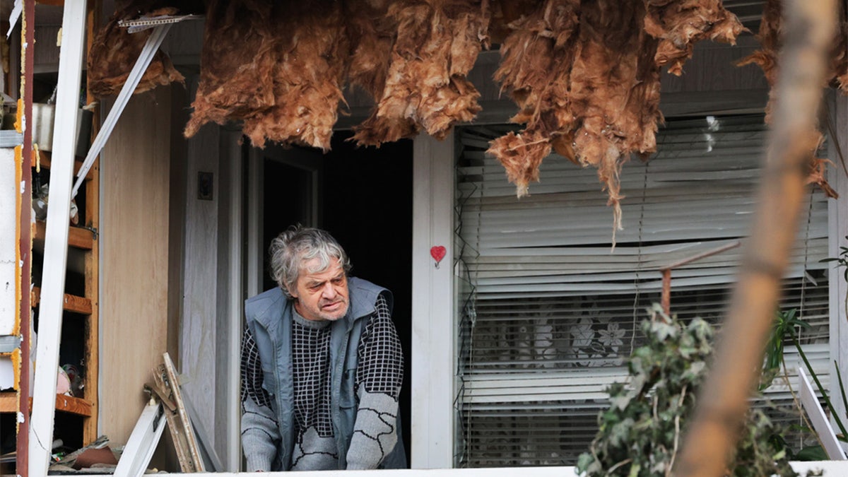 Ukrainian man near damaged balcony in Zaporizhzhia