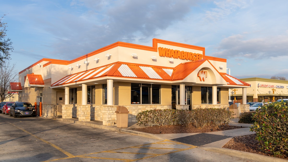 Cars wait in the drive-thru line at a Whataburger.