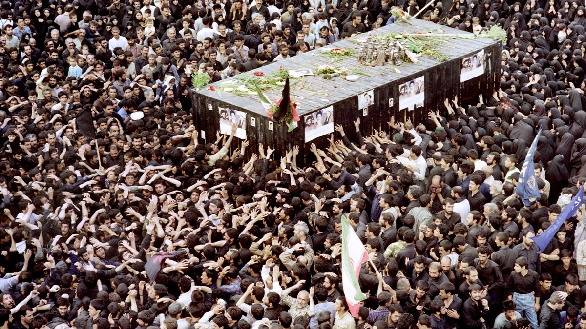 Mourners press forward around the casket at Ayatollah Ruhollah Khomeini’s tomb in Tehran’s Behesht Zahra cemetery.