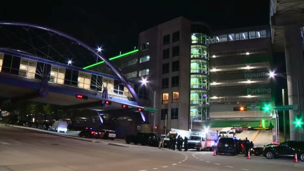 Dallas police vehicles and officers outside Children’s Medical Center Dallas at night during SWAT response