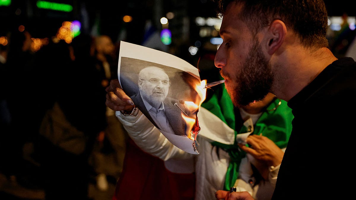 Burning picture of Iranian Parliament Speaker Mohammad Bagher Ghalibaf, as Israelis rally in support of the nationwide protests