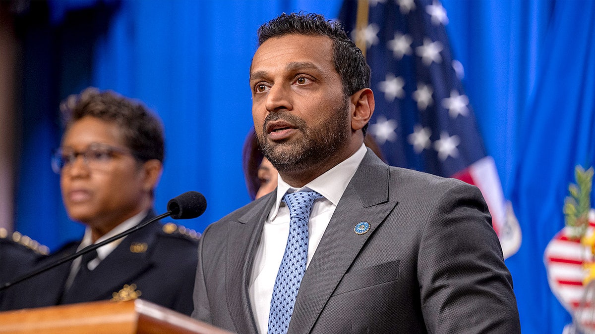 FBI Director Kash Patel speaks at a podium during a news conference inside the Justice Department.