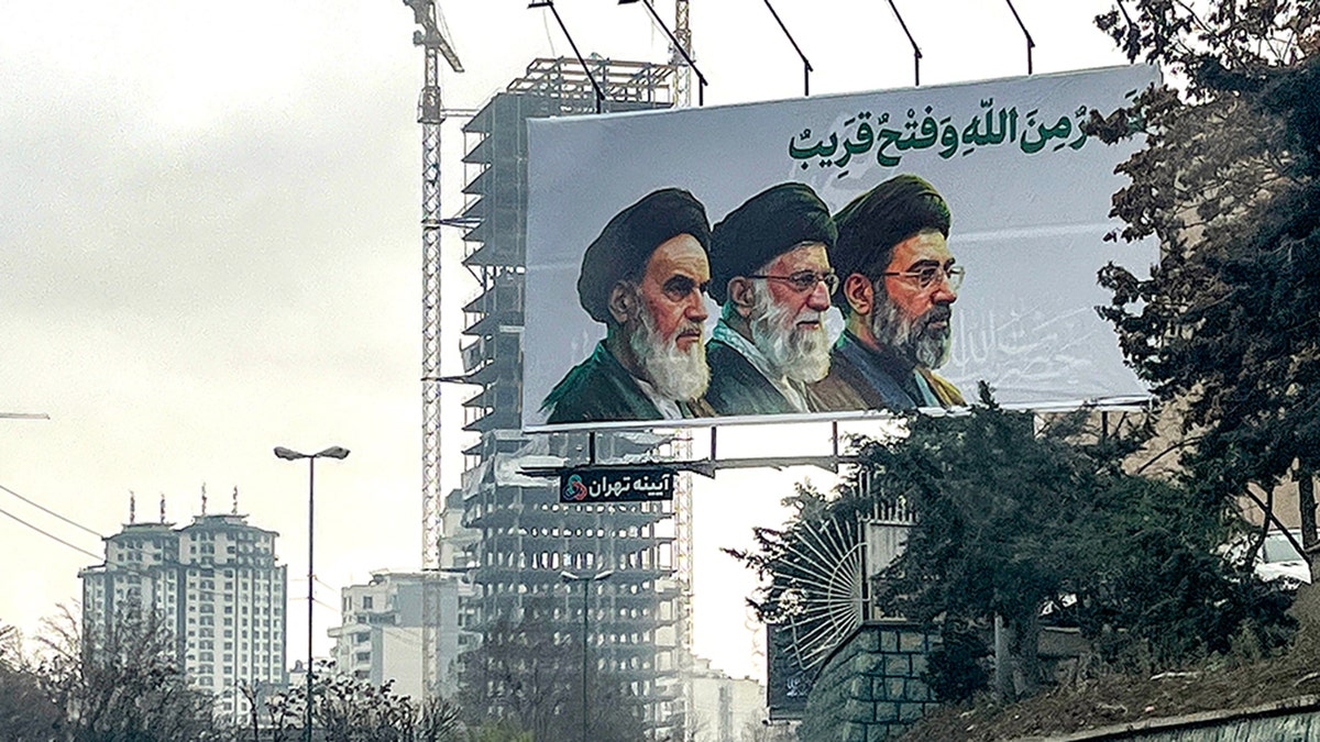 Billboard showing Iran's supreme leaders Ruhollah Khomeini, Ali Khamenei, and Mojtaba Khamenei above a highway in Tehran