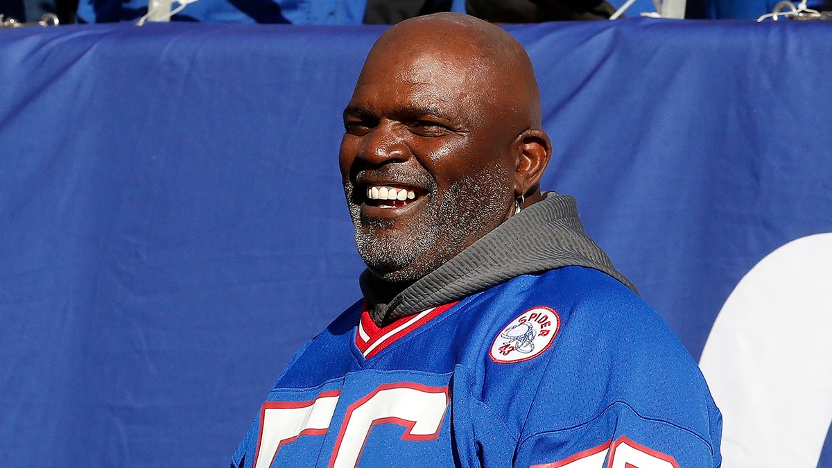 Lawrence Taylor standing on the sidelines at MetLife Stadium during a football game