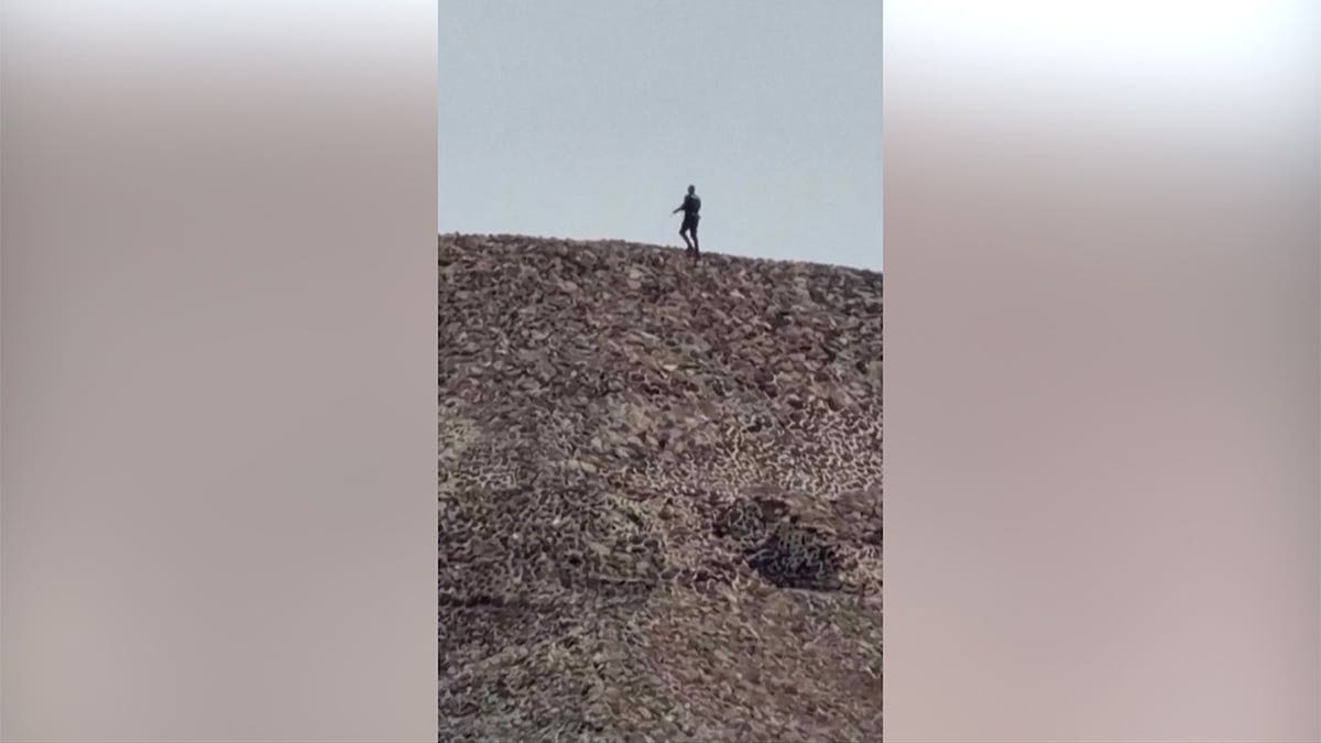 Gunman walks on pyramid