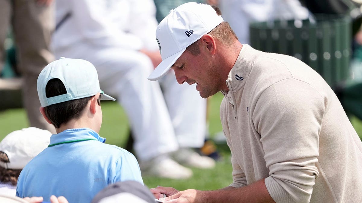 Bryson DeChambeau signing autographs at the Masters Tournament Par 3 Contest