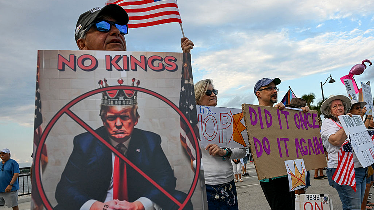 Protesters hold signs and flags