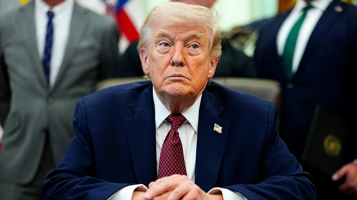 President Donald Trump sits at the Resolute Desk in the Oval Office