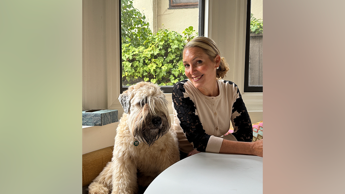 Amy Hillyard smiling beside a dog