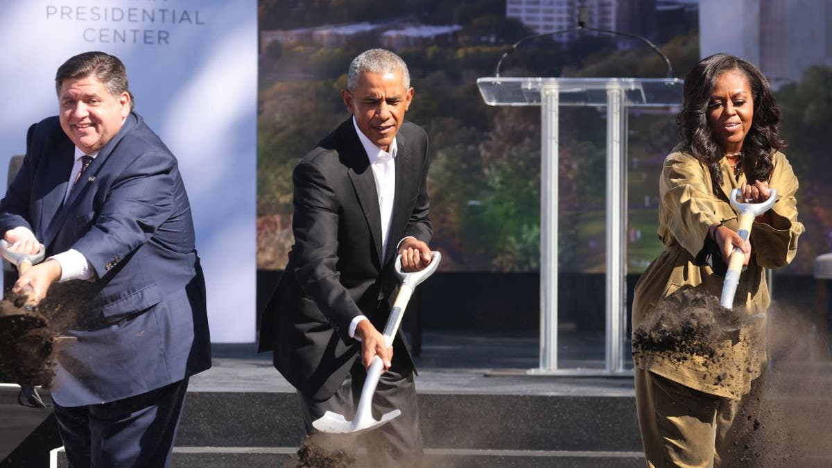 Illinois Gov. J.B. Pritzker standing with former President Barack Obama and former first lady Michelle Obama at a groundbreaking ceremony