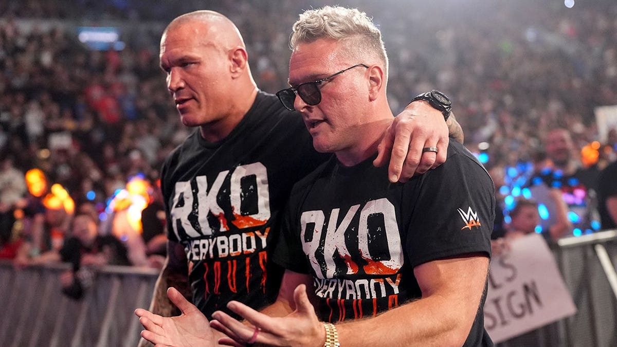 Pat McAfee and Randy Orton standing together in a wrestling ring