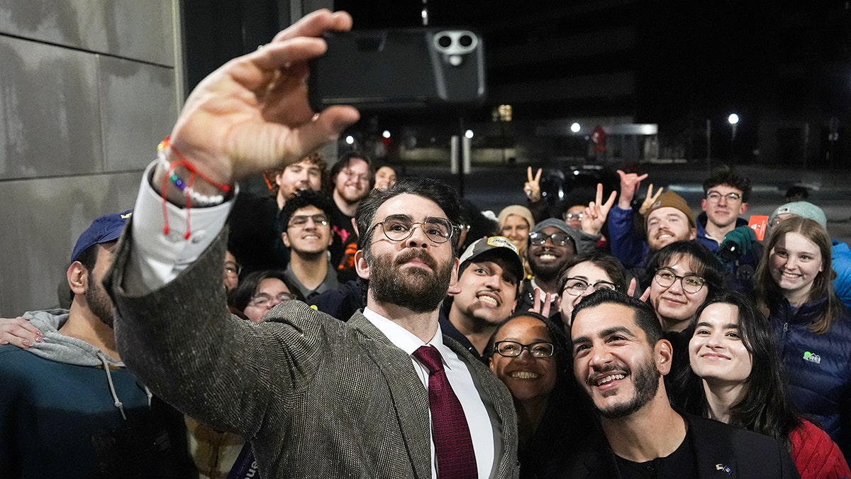Hasan Piker and Abdul El-Sayed take a selfie with a group of young fans.