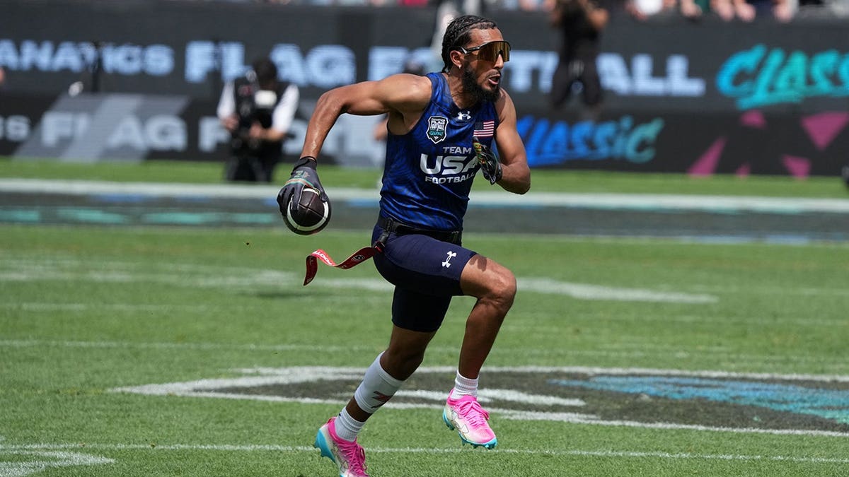 Team USA quarterback Darrell Doucette III carrying football on field