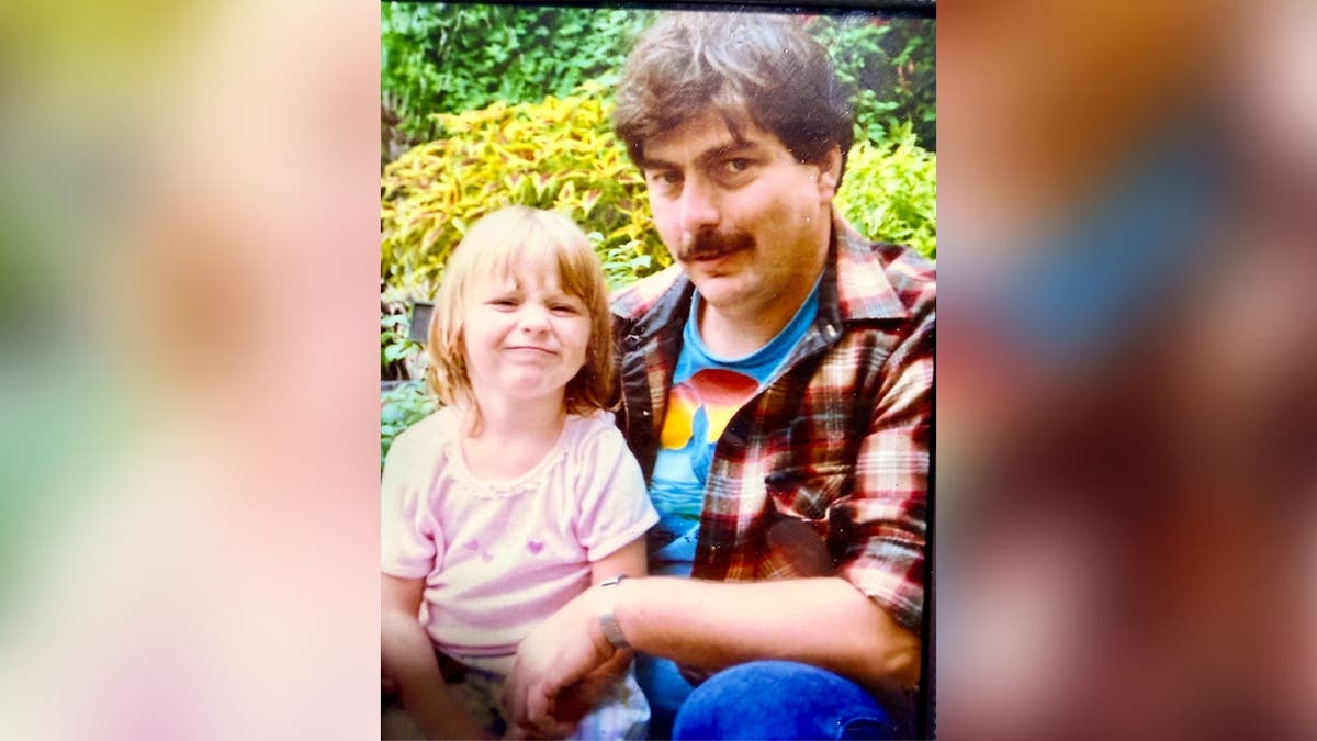 An older photo of Lloyd Poole sitting with his daughter