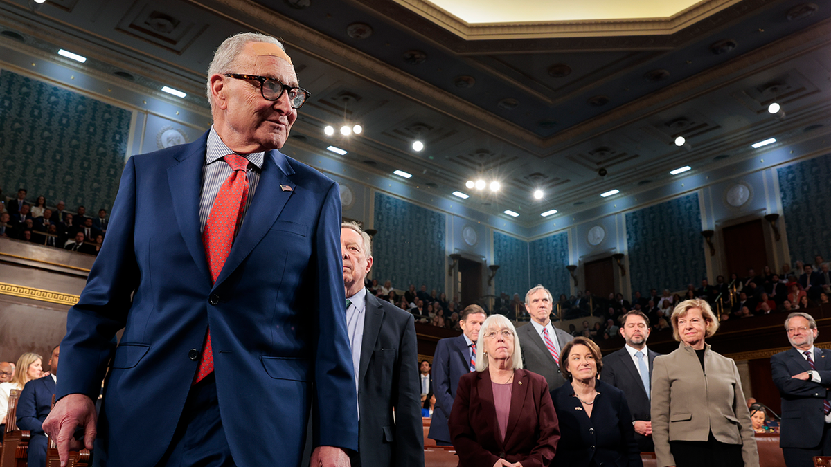 Senate Minority Leader Chuck Schumer speaking at a podium