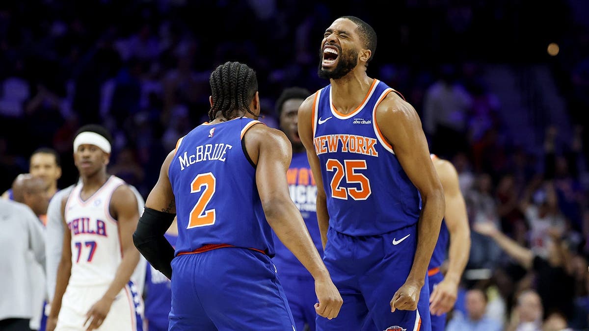 Miles McBride and Mikal Bridges celebrating during NBA playoff game at Xfinity Mobile Arena