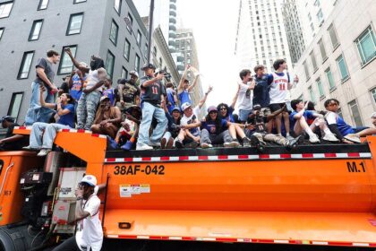 Knicks fans climb on police cars, sanitation trucks as countless others unable to get into jam-packed parade