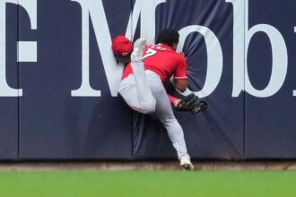 Reds’ Dane Myers carted off field after crashing into wall making acrobatic catch vs Brewers