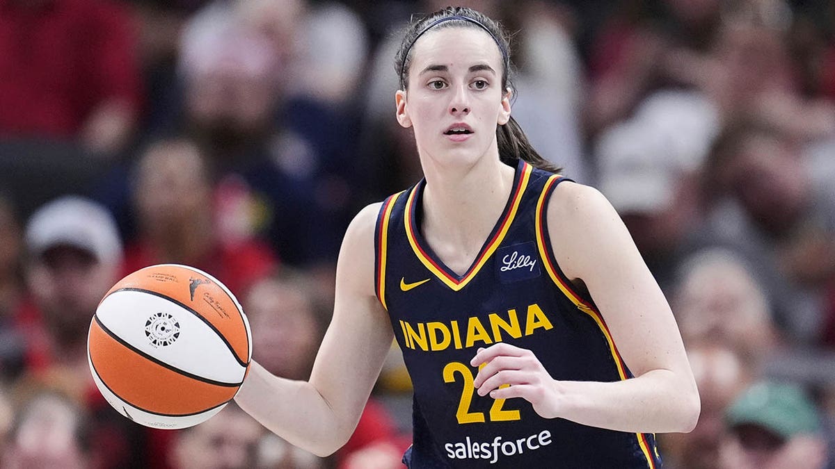 Indiana Fever guard Caitlin Clark dribbling basketball against Dallas Wings in game