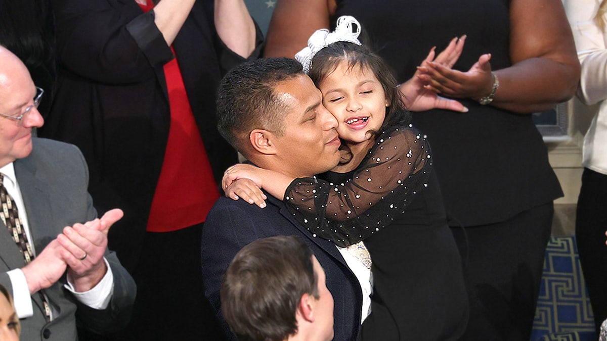 Marcus Coleman holds his daughter Dalilah Coleman during State of the Union address at U.S. Capitol