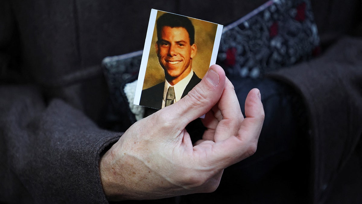 Mick Bonanno holding a picture of Erik Menendez while waiting in line outside Van Nuys Courthouse