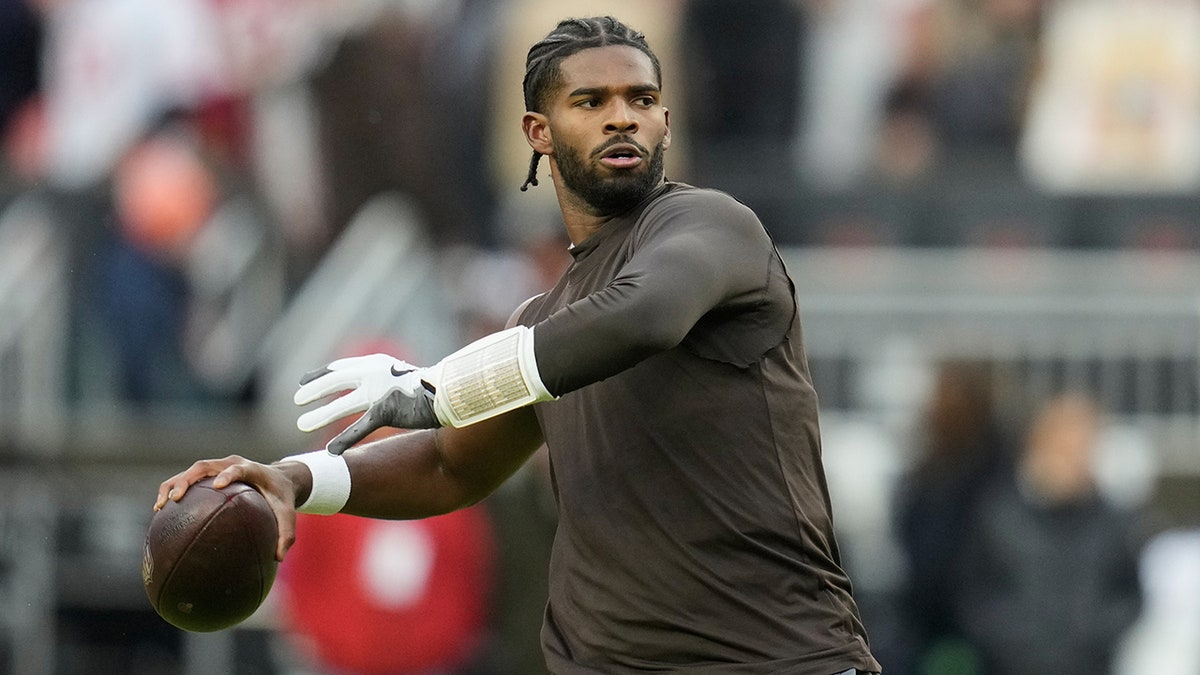 Shedeur Sanders warming up on the football field in Cleveland