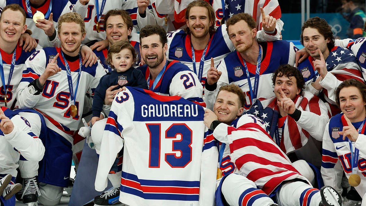United States ice hockey players celebrating with Johnny Gaudreau jersey at Milano Santagiulia Ice Hockey Arena