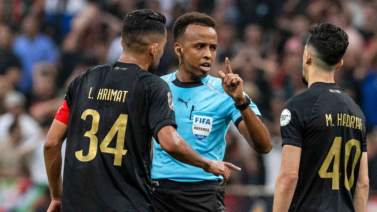 Referee Omar Artan is confronted by players during a soccer match in Rabat, Morocco.