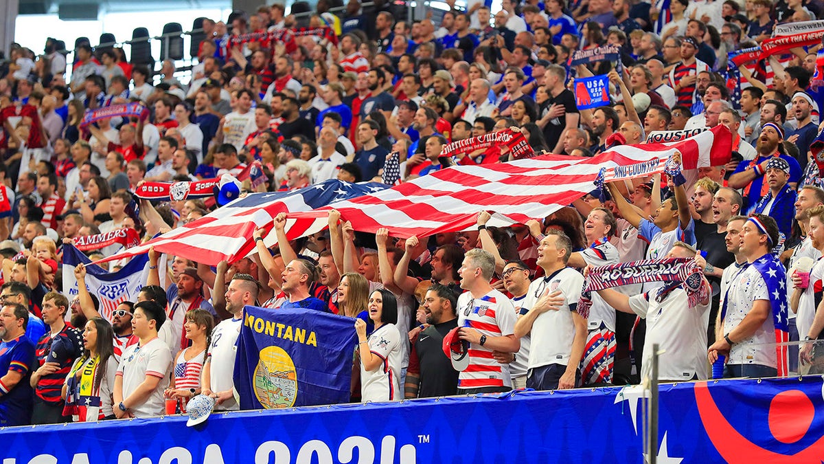 Team USA fans celebrating with a flag at Mercedes-Benz Stadium in Atlanta, Georgia