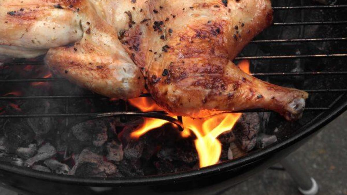 chicken being grilled over charcoal
