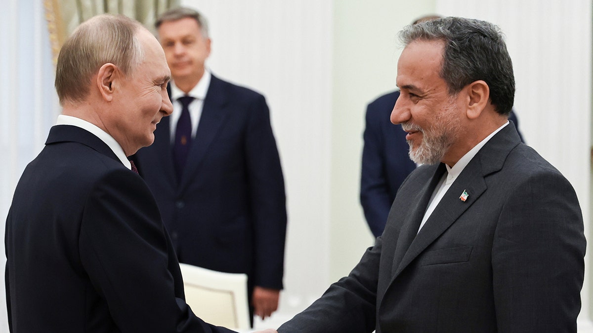 Russian President Vladimir Putin greets Iranian Foreign Minister Abbas Araghchi