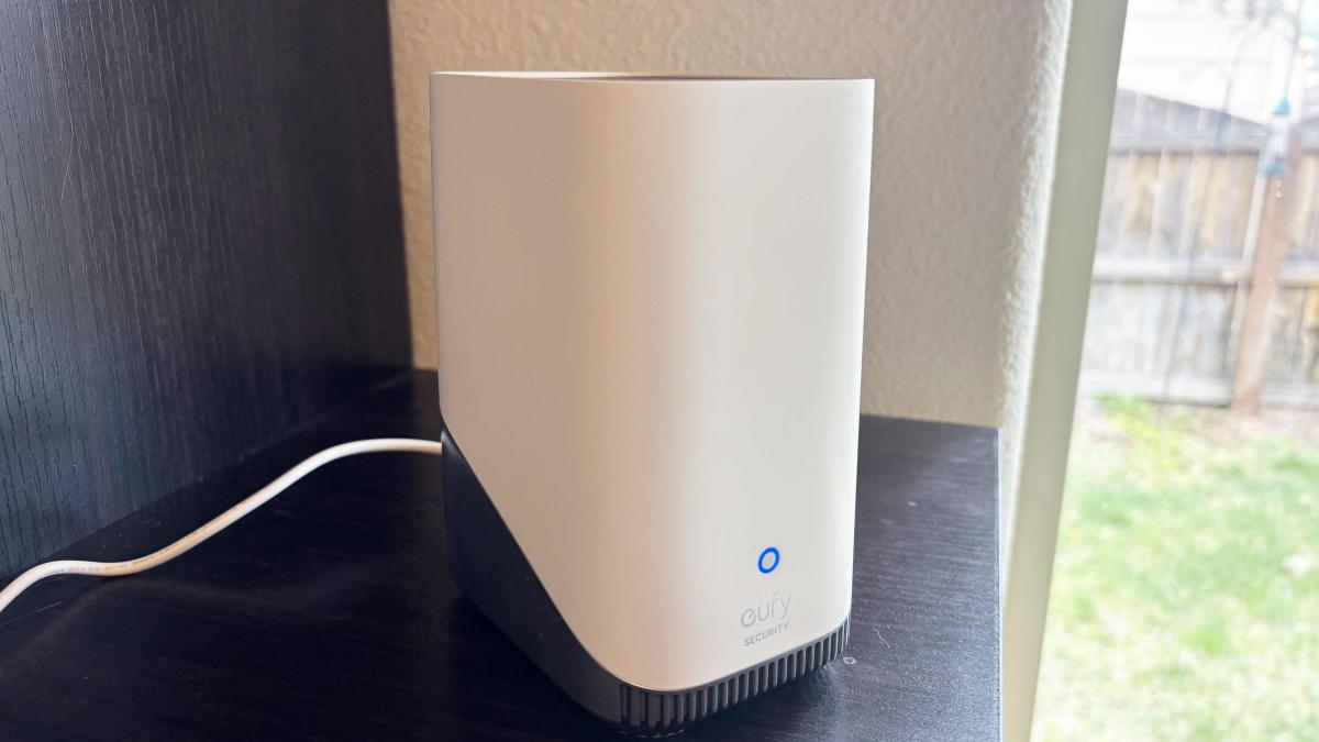 Eufy's HomeBase 3 on a black shelf by a window.