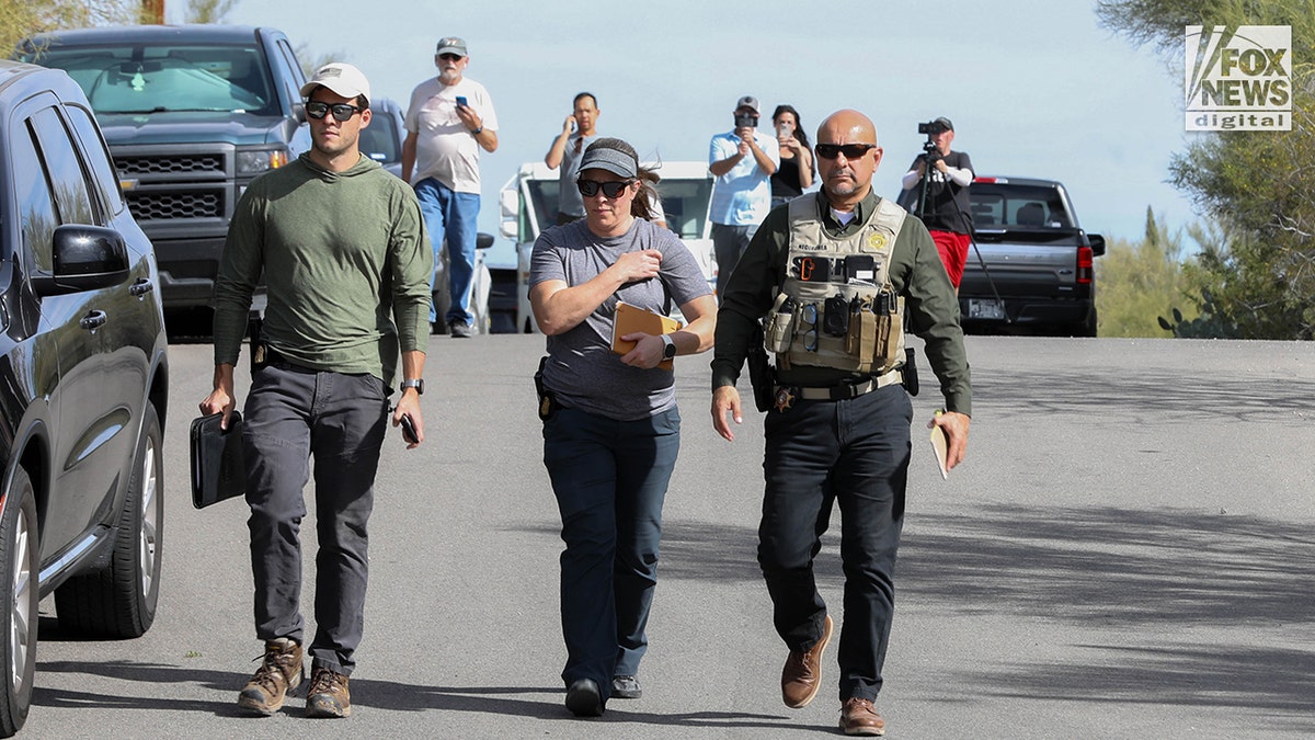 FBI investigators wearing tactical vests walking through Annie Guthrie's neighborhood in Tucson, Arizona