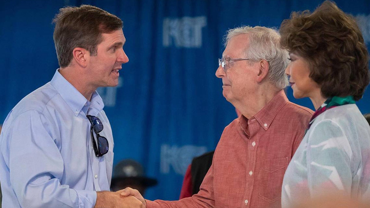 Kentucky Gov. Andy Beshear greets Sen. Mitch McConnell and his wife Elaine Chao