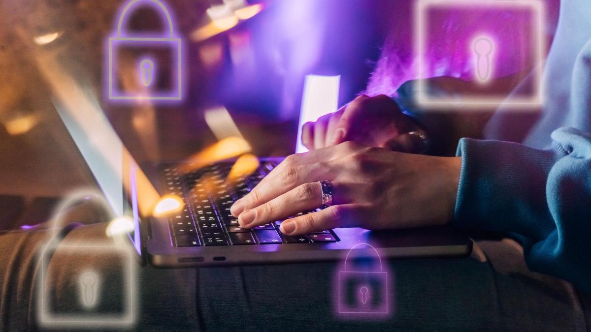 A person's hands on their keyboard with images of locks flying around the screen.