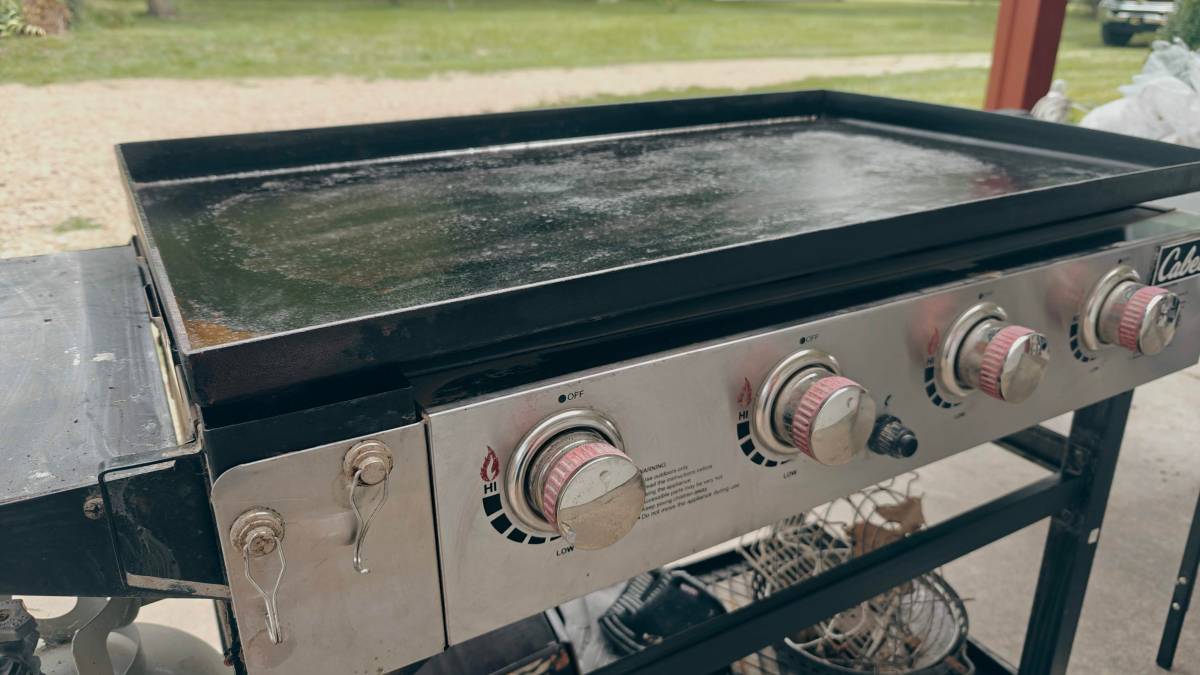 A seasoned griddle sitting on a patio.