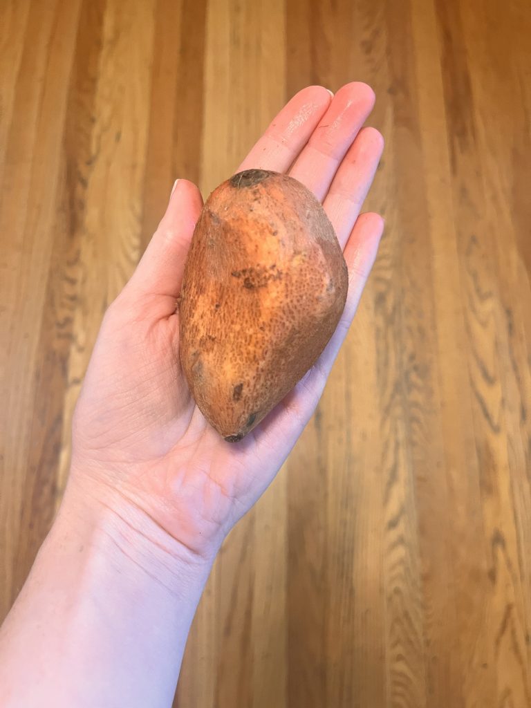 a person holding a sweet potato